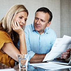 Couple Looking at Utility Bills, a man and a woman at a table looking at various bills