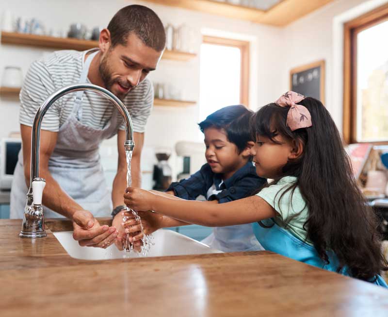 UtilityShield Family Washing Hands, father with two young children together washing hands